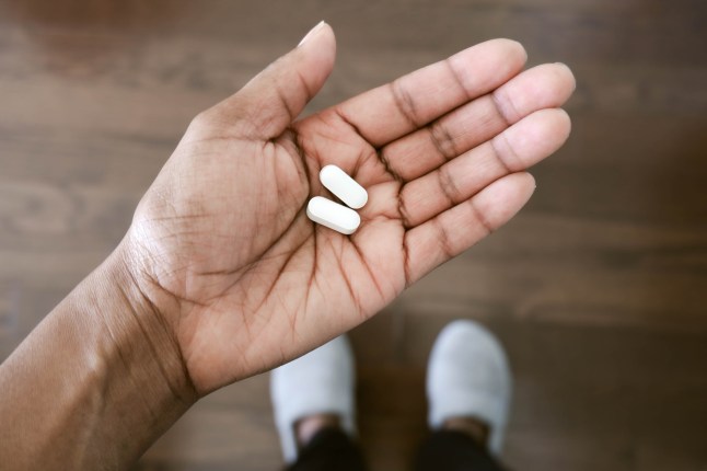 Woman Holds painkillers.