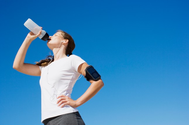 Woman runner drinking from water bottle