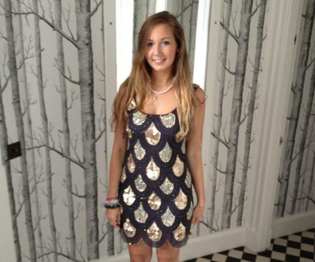 Younger Alex Meyer smiles, wearing a black patterned dress